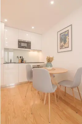 a kitchen and dining room with a table and chairs at Canto Flores in Porto