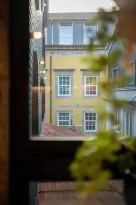 a view of a yellow building from a window at Charming Blue Apartment in Porto