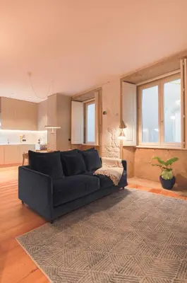a living room with a black couch and a rug at Charming Blue Apartment in Porto