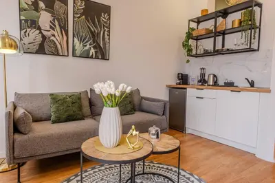 a living room with a couch and a vase of flowers on a table at River Corticeira II in Porto