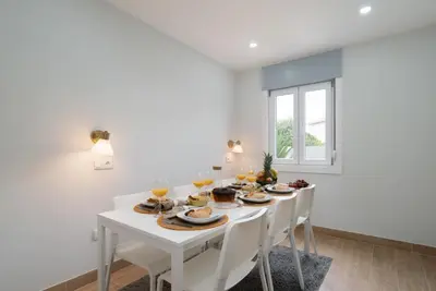 a white dining room with a white table and chairs at Charming Bright House w/ Garden by HostWise in Porto