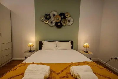 a bedroom with a large bed with plates on the wall at River Corticeira I in Porto