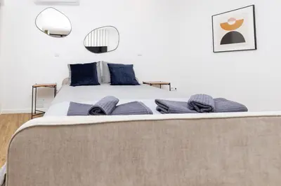 a bedroom with a large bed with blue pillows at Trindade Trendy Studio 15 in Porto