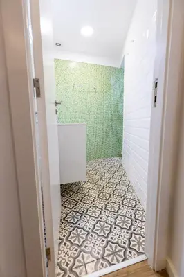 a bathroom with a shower with a tiled floor at Trindade Trendy Studio 15 in Porto