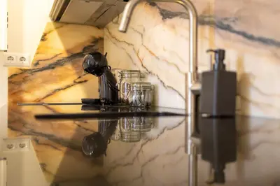 a bathroom with a counter with glasses on a marble wall at Trindade Trendy Studio 15 in Porto