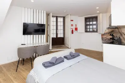 a white bedroom with a bed with purple towels on it at Trindade Trendy Studio 15 in Porto