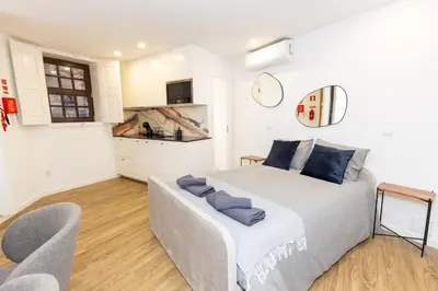 a bedroom with a bed and a couch and a kitchen at Trindade Trendy Studio 15 in Porto