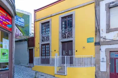 a yellow building with a door and a balcony at Trindade Trendy Studio 15 in Porto