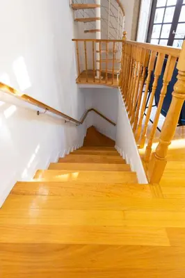 a staircase with wood floors and a wooden railing at Trindade Trendy Studio 17 in Porto