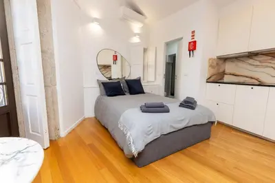 a bedroom with a large bed with a mirror on the wall at Trindade Trendy Studio 17 in Porto