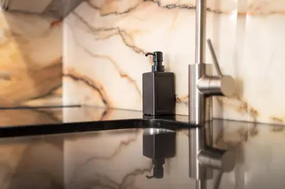 a soap dispenser sitting on a glass table in a bathroom at Trindade Trendy Studio 17 in Porto