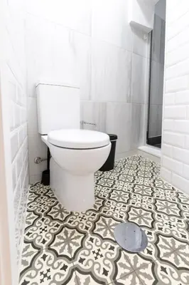 a bathroom with a toilet and a tile floor at Trindade Trendy Studio 17 in Porto