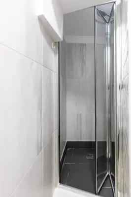 a shower with a glass door in a bathroom at Trindade Trendy Studio 17 in Porto
