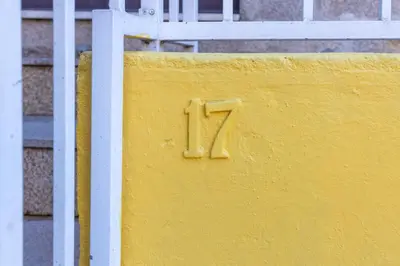 a yellow wall with a number on it next to a fence at Trindade Trendy Studio 17 in Porto