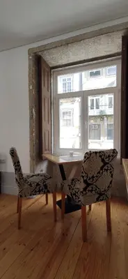 a table and two chairs in a room with a window at Ribeira Riverview Panoramic in Porto