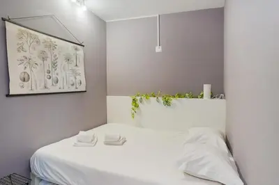 a bedroom with a white bed with plants on the wall at Island House in Porto