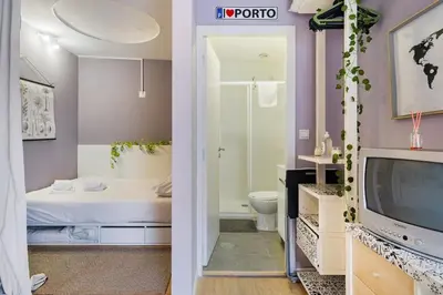 a bathroom with a toilet and a shower and a television at Island House in Porto