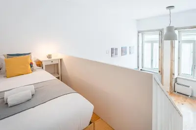 a white bedroom with a large bed and a window at GuestReady - A lovely city retreat in Porto