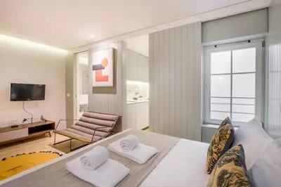 a bedroom with a large bed with two white towels at Oporto Exquisite Apartment in Porto