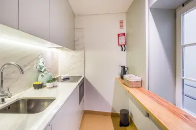 a kitchen with white counters and a sink at Oporto Exquisite Apartment in Porto