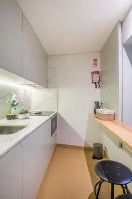 a kitchen with white cabinets and a black stool at Oporto Exquisite Apartment in Porto