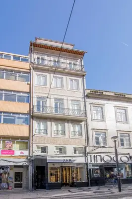 a tall building on a city street with a store at Oporto Exquisite Apartment in Porto