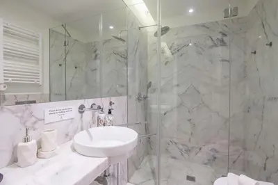 a bathroom with a sink and a glass shower at Oporto Exquisite Apartment in Porto