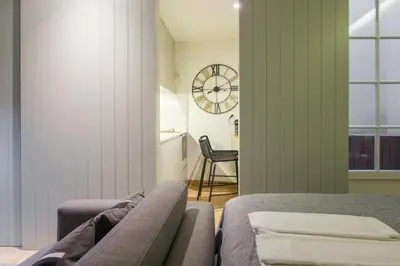a bedroom with a couch and a clock on the wall at Pleasant Studio Santa Catarina in Porto