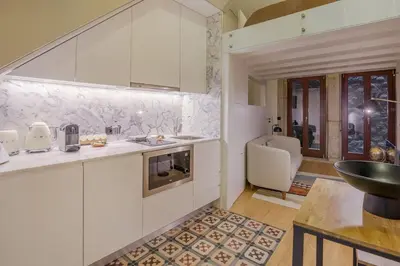 a kitchen with white cabinets and a sink at Tailor's Apartments II in Porto