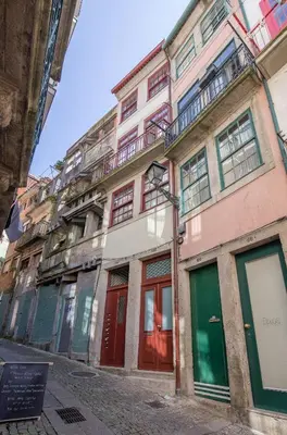 a building with red doors and windows on a street at Tailor's Apartments II in Porto