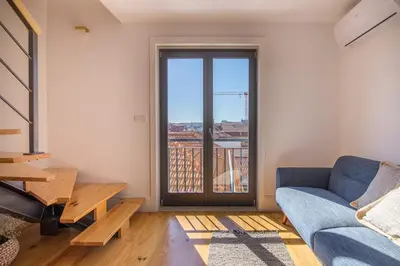 a living room with a couch and a large window at Topo Flores Apartment in Porto