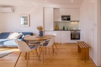a kitchen and dining room with a table and chairs at Topo Flores Apartment in Porto