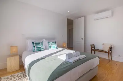a bedroom with a large bed with towels on it at Topo Flores Apartment in Porto