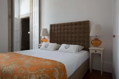 a bedroom with a large bed with a large headboard at Porto Vintage Guesthouse in Porto
