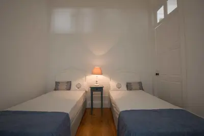 two beds in a room with a lamp on a table at Porto Vintage Guesthouse in Porto