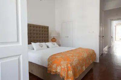 a bedroom with a large bed with an orange blanket at Porto Vintage Guesthouse in Porto