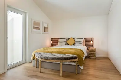 a bedroom with a large bed and a window at Valadouro Duplex Factory - Maison dans Porto in Porto