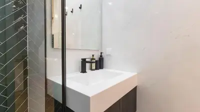 a bathroom with a white sink and a mirror at New 3BR w Rooftop & Balcony Views by LovelyStay in Porto