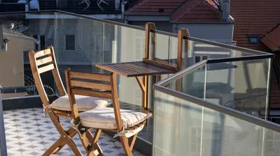 a chair and a desk on a balcony at New 3BR w Rooftop & Balcony Views by LovelyStay in Porto