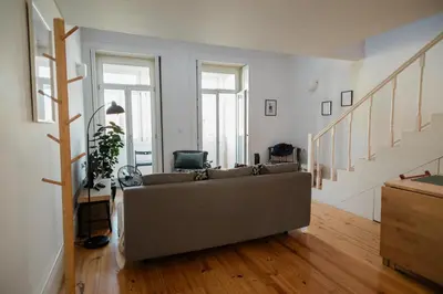 a living room with a couch and stairs at Downtown Urban Nest in Porto
