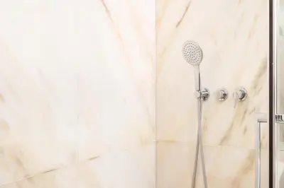 a shower with a shower head in a bathroom at Modern Camões Flat, In the Heart of Porto in Porto