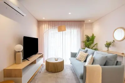 a living room with a blue couch and a tv at Modern Camões Flat, In the Heart of Porto in Porto