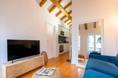 a living room with a large tv and a blue couch at HostWise - Stylish Retreat in Porto's Heart in Porto