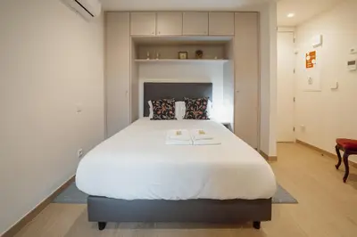 a bedroom with a large white bed in a room at Carmo Residence Porto by Vacationy in Porto