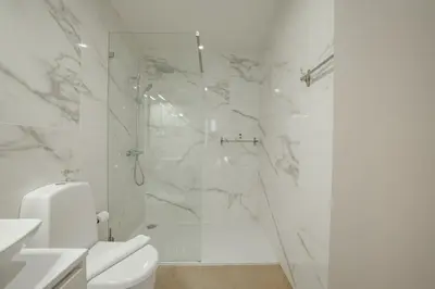 a white bathroom with a shower and a toilet at Carmo Residence Porto by Vacationy in Porto