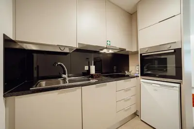 a kitchen with white cabinets and a sink at Carmo Residence Porto by Vacationy in Porto