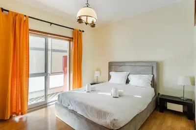 a bedroom with a large bed and a large window at GuestReady - Bonfim Cozy Retreat in Porto