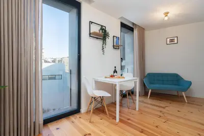 a room with a white table and a blue chair at Stylish Studio in Porto Downtown by HostWise in Porto