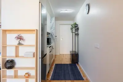 a hallway with a door to a kitchen with a rug at Stylish Studio in Porto Downtown by HostWise in Porto