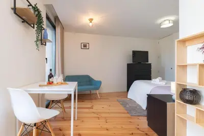 a small room with a bed and a table and chairs at Stylish Studio in Porto Downtown by HostWise in Porto